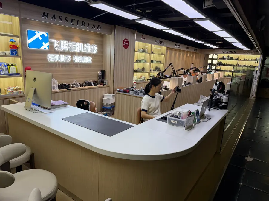 飞腾相机快修维修区玻璃隔断与多名驻店技师工作位